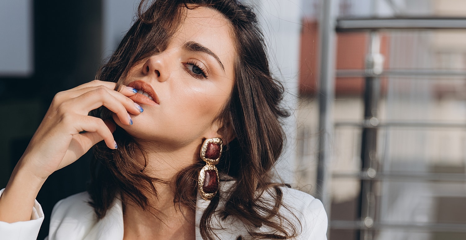 Houston plastic surgery model with stylish earrings and glamorous makeup.