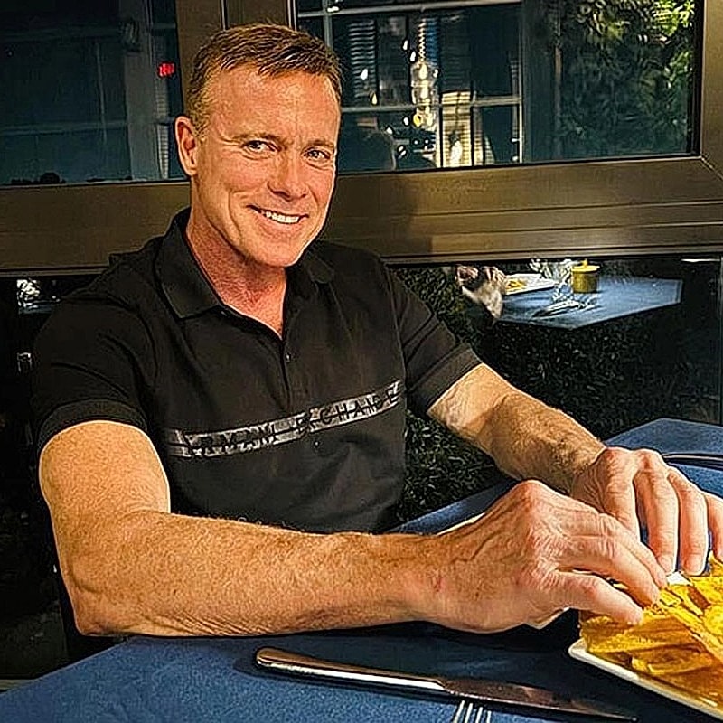 Houston plastic surgery patient enjoying food at a table with bluecloth.