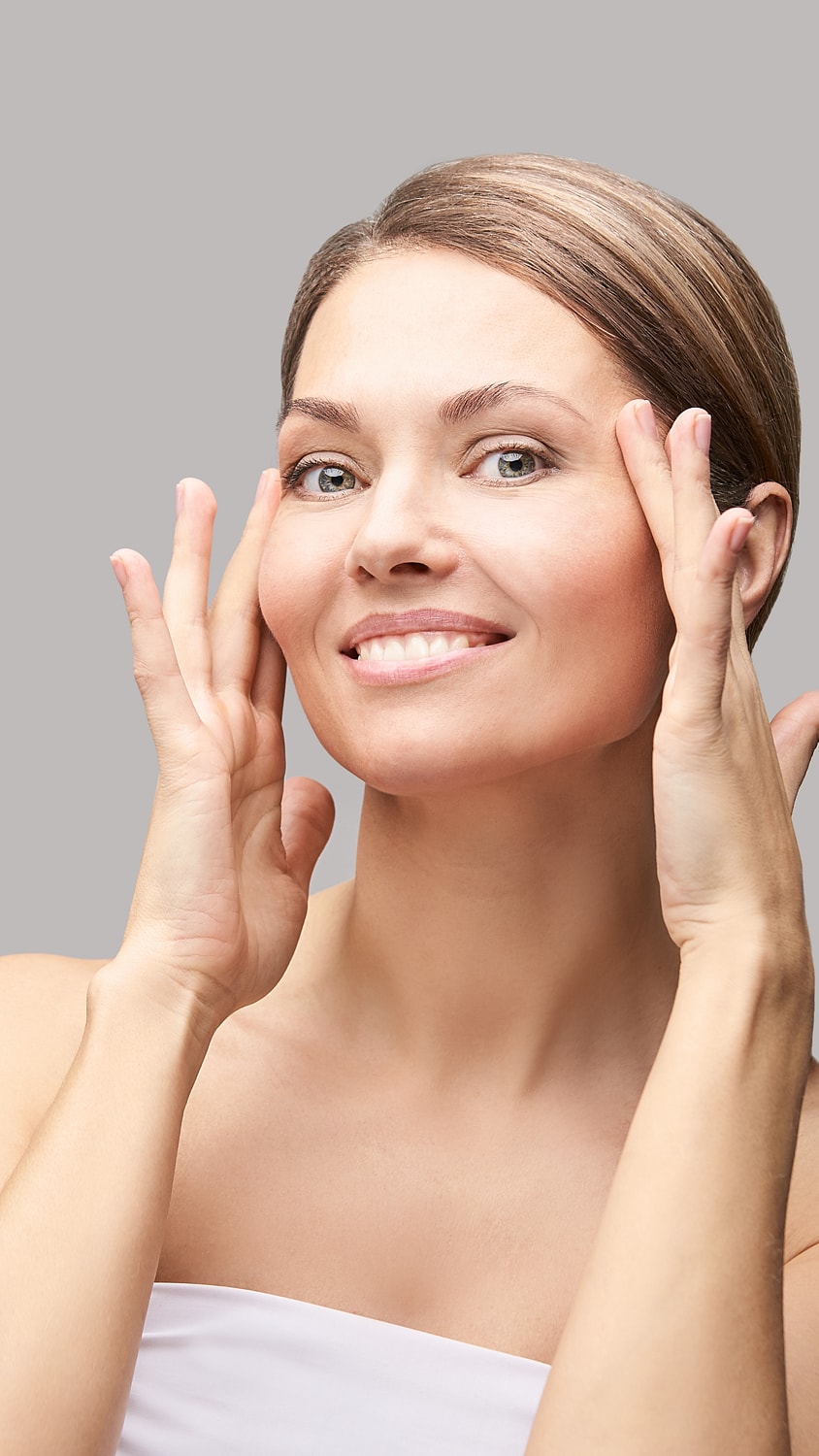 Woman showing skincare routine with a smile.