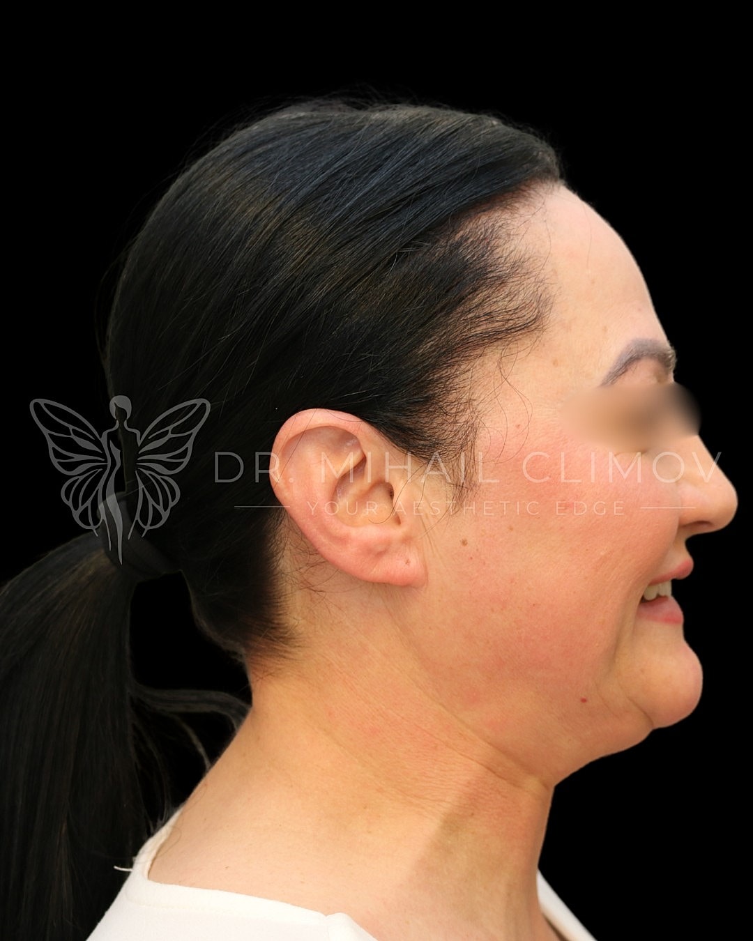Profile view of a smiling woman with ponytail.